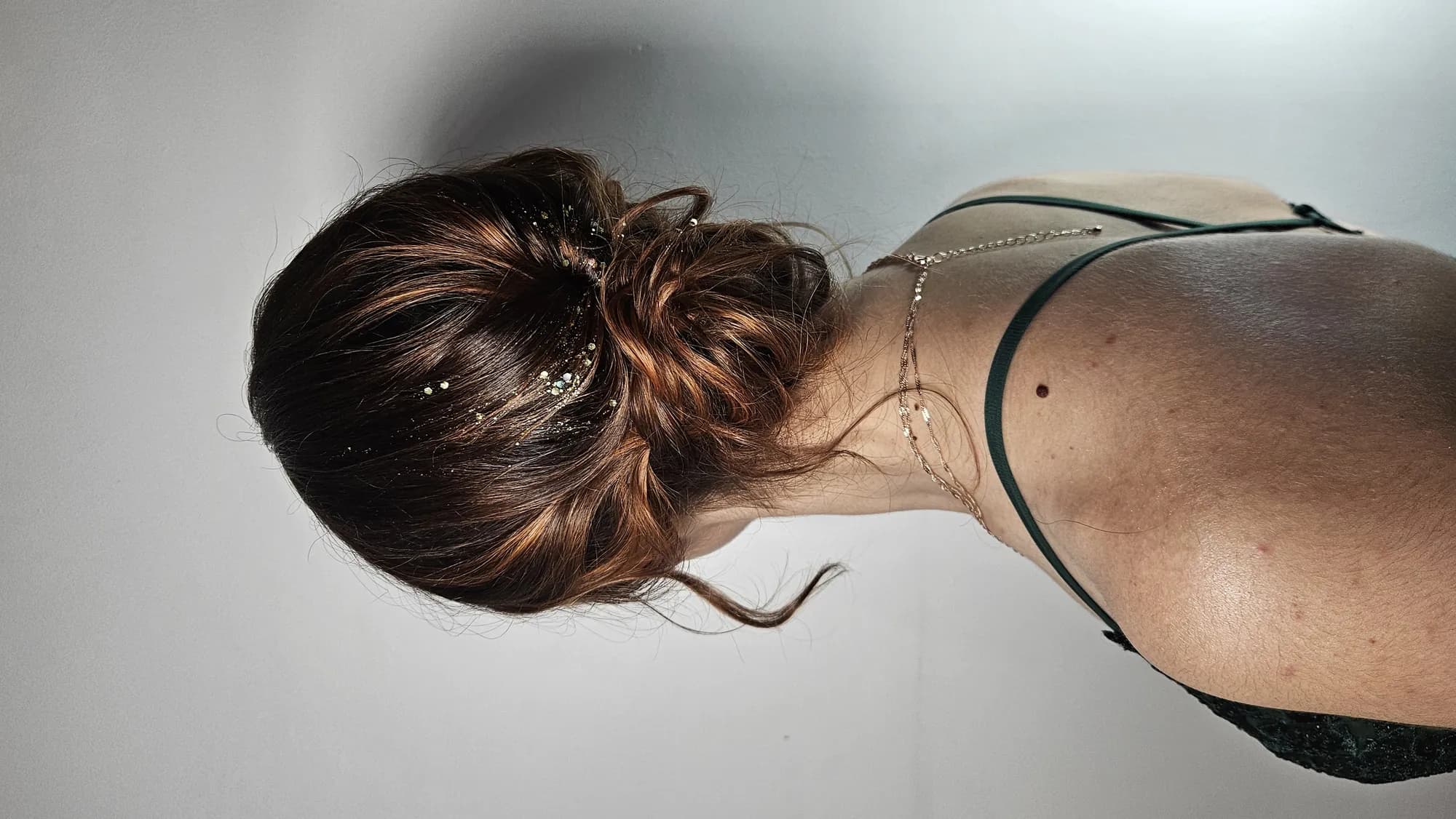 Chignon bas travaillé, vu de dos sur fond clair